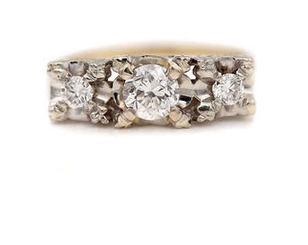 May include: A gold and silver ring with three round diamonds. The center diamond is larger than the two side diamonds.