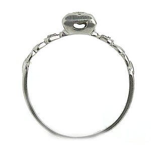 May include: A silver ring with a delicate design and a small, clear stone in the center.