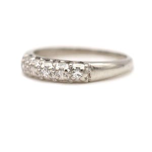May include: A silver band ring with a row of small diamonds set in a pave setting.