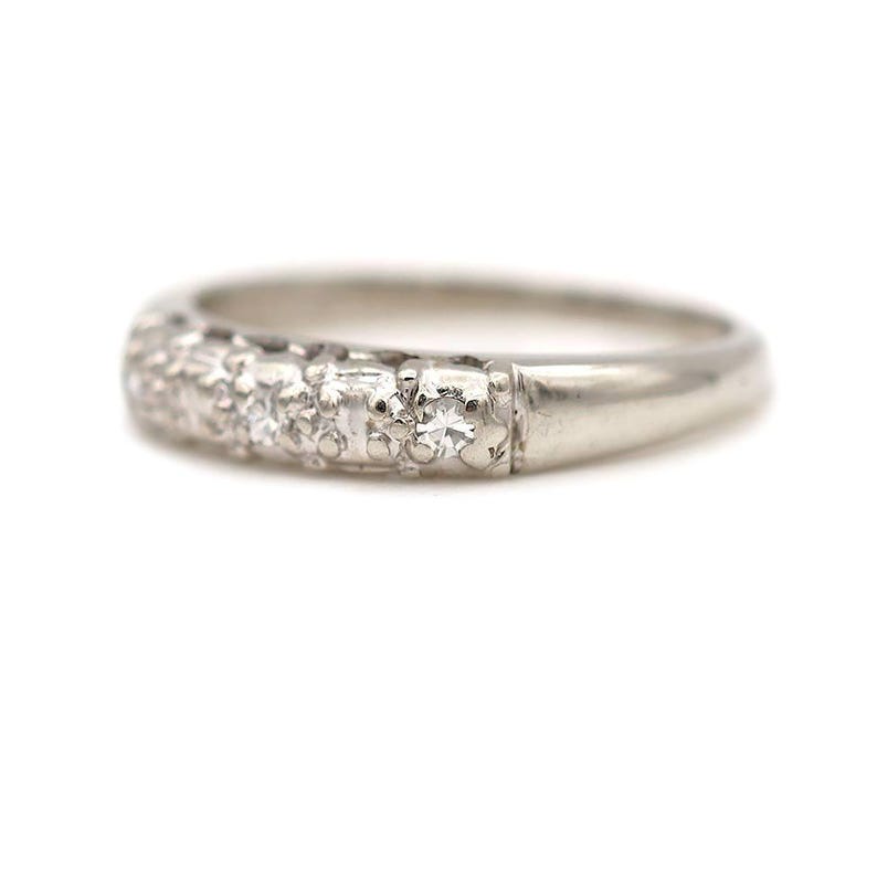 May include: A silver band ring with a row of small diamonds set in a pave setting.