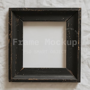 May include: Square black wooden frame with distressed edges. The frame has the words "Frame Mockup" and "PSD SMART OBJECT" in the center. The frame is set against a white, textured background.