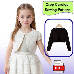 Può includere: Una bambina indossa un cardigan corto in pizzo bianco e una gonna. Un cardigan corto nero è mostrato su un appendiabiti, con il testo "Crop Cardigan Sewing Pattern" sopra. Un'icona PDF è in basso a destra.