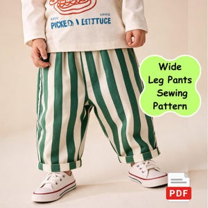 May include: A child in a cream-coloured long-sleeved top with a graphic and green and white striped wide-leg trousers. The trousers are cuffed at the ankles. White trainers with red and blue trim complete the outfit. Text on the image reads "Wide Leg Pants Sewing Pattern".