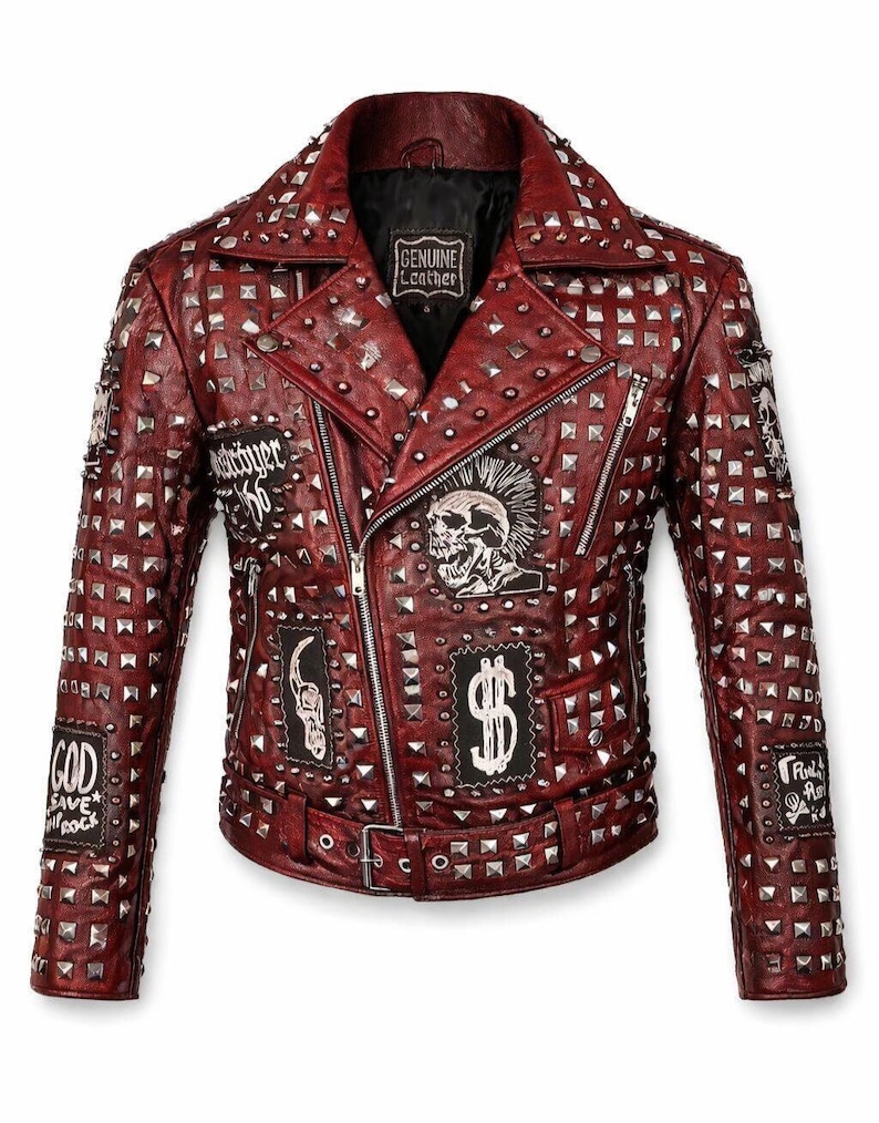Front view of a red studded leather jacket featuring silver pyramid studs across the collar, shoulders, and body, with skull patches and an asymmetrical biker zipper on a clean white background.