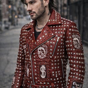 Model wearing red punk leather jacket with heavy silver studs, styled for edgy streetwear and rocker fashion look.