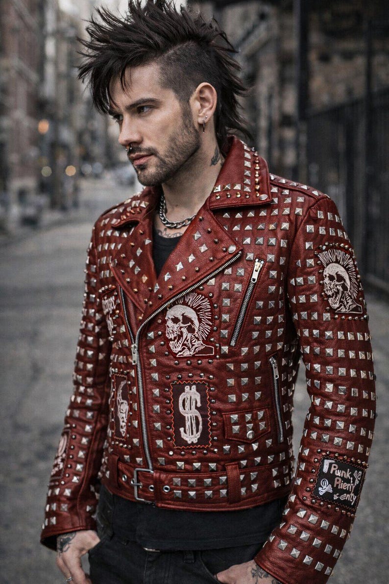 Model wearing red punk leather jacket with heavy silver studs, styled for edgy streetwear and rocker fashion look.