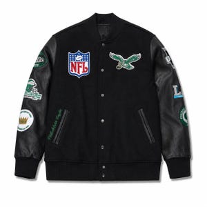 May include: A black varsity jacket with black leather sleeves and a snap-button front. The chest features an NFL logo patch and a Philadelphia Eagles eagle emblem. Both sleeves are adorned with various embroidered team patches and logos.