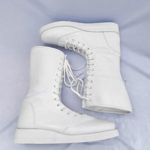 Professional white wrestling boots crafted from durable genuine leather, offering excellent grip, support, and flexibility. These custom laced-up pro wrestling shoes are designed for athletes, performers, and sports enthusiasts who need reliable footwear for intense movement and competition.