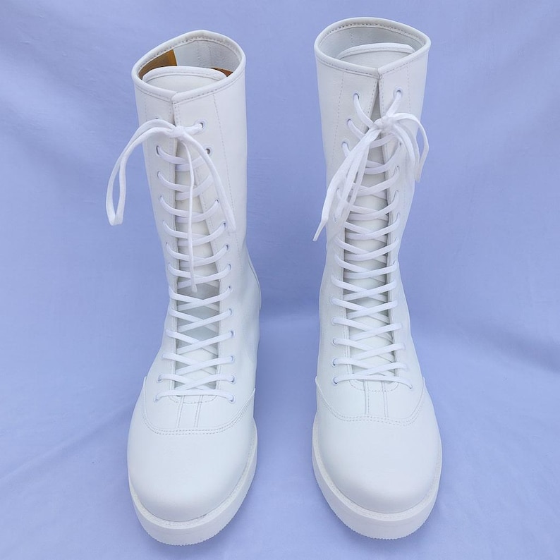 Custom white wrestling boots made from premium genuine leather, designed for professional wrestlers seeking durability, comfort, and performance. These white lace-up pro wrestling shoes feature reinforced stitching, strong ankle support, and a sleek high-top silhouette ideal for training, matches, and competitions.