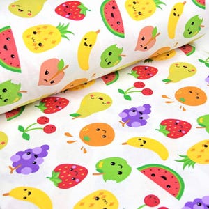 May include: White fabric roll featuring a vibrant pattern of cartoon fruits with smiling faces. The design includes strawberries, bananas, watermelons, pineapples, grapes, pears, cherries, and oranges. Ideal for crafting.