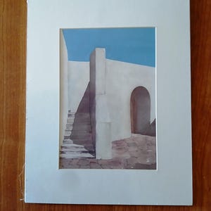 Puede incluir: Una pintura de acuarela de un edificio blanco con un cielo azul de fondo. El edificio tiene una puerta y una escalera que conduce a &eacute;l.