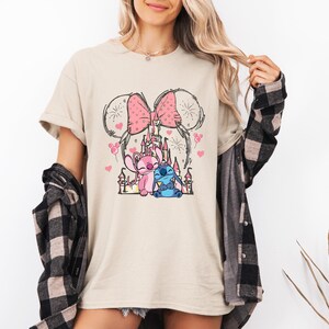 Stitch Angel castle shirt with Minnie ears and pink bow design Disney couple shirt with Stitch and Angel inspired characters pink Disney vacation tee with castle hearts and fireworks Minnie ears castle shirt with cute Stitch Angel graphic theme park outfit shirt with magical castle and pink bow Stitch and Angel Disney shirt for couple vacation outfit cute Disney lover gift shirt with castle and hearts design white Disney inspired graphic tee with Stitch Angel artwork