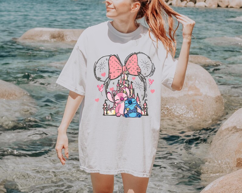 Stitch Angel castle shirt with Minnie ears and pink bow design Disney couple shirt with Stitch and Angel inspired characters pink Disney vacation tee with castle hearts and fireworks Minnie ears castle shirt with cute Stitch Angel graphic theme park outfit shirt with magical castle and pink bow Stitch and Angel Disney shirt for couple vacation outfit cute Disney lover gift shirt with castle and hearts design white Disney inspired graphic tee with Stitch Angel artwork