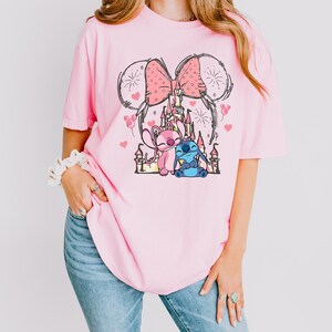 Stitch Angel castle shirt with Minnie ears and pink bow design Disney couple shirt with Stitch and Angel inspired characters pink Disney vacation tee with castle hearts and fireworks Minnie ears castle shirt with cute Stitch Angel graphic theme park outfit shirt with magical castle and pink bow Stitch and Angel Disney shirt for couple vacation outfit cute Disney lover gift shirt with castle and hearts design white Disney inspired graphic tee with Stitch Angel artwork