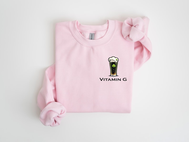 A pink sweatshirt with a graphic of a beer glass and the text "Vitamin G" printed on it.