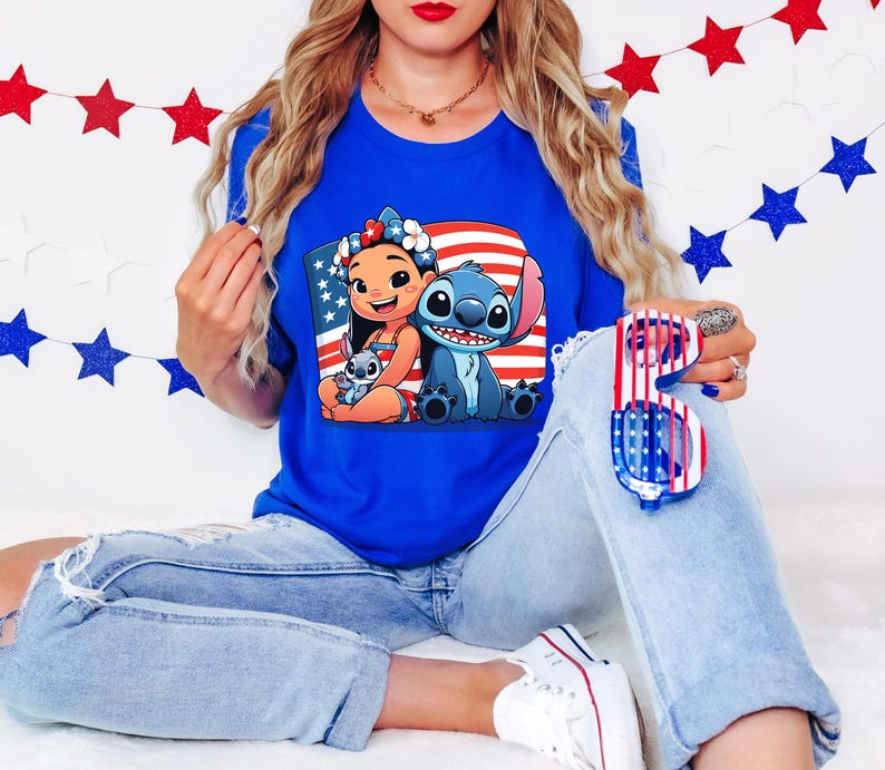 May include: A royal blue t-shirt featuring a graphic of Lilo and Stitch with an American flag background. The image also includes red, white, and blue star decorations and sunglasses.