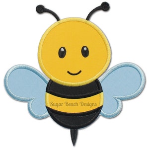 Può includere: Un'ape di cartone animato con strisce nere e gialle, ali blu e un viso giallo sorridente. L'ape ha un piccolo pungiglione nero. Il testo "Sugar Beach Designs" è stampato sull'addome dell'ape.