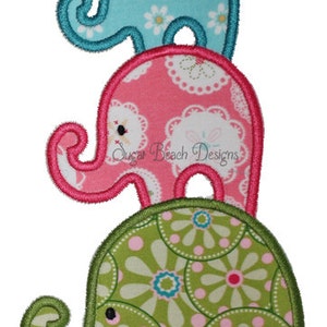 May include: Three stacked elephant appliqués in blue, pink, and green. Each elephant has a unique floral pattern and a stitched outline. The top elephant is light blue with white daisies, the middle is pink with white lace, and the bottom is green with pink and blue flowers.