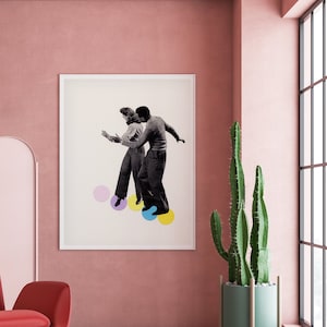Könnte beinhalten: Ein roter Sessel mit einer weißen Lampe, die darüber hängt, in einem rosa Raum mit einem gerahmten Schwarzweißfoto eines Paares, das auf einem Hintergrund aus bunten Kreisen tanzt. Ein Kaktus in einem grünen Topf steht in der Ecke des Raumes neben einem großen Fenster.