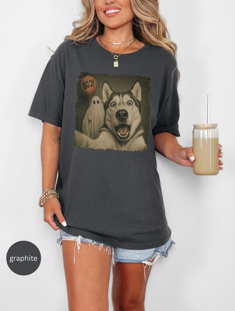 Startled Husky taking a Halloween selfie with a sheet ghost holding an orange BOO balloon in a distressed vintage photo design.