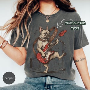 Op de afbeelding: Een set van drie keramische mokken met een gespikkelde, matte afwerking. De mokken zijn in crème, lichtgrijs en donkergrijs. Elke mok heeft een eenvoudig, modern ontwerp en een afgeronde handgreep.