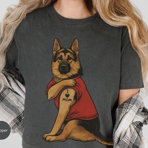 German Shepherd dog illustration wearing a red shirt, lifting sleeve to reveal “I love mom” tattoo, vintage style retro pet graphic, bold clean lines, centered composition, perfect for dog lovers and animal themed apparel designs