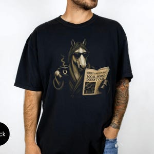 Vintage engraved horse wearing sunglasses and a robe while reading a newspaper and holding a steaming coffee mug. Humorous horse lover design featuring the headline “Local Horse Doesn't Care” in an antique newspaper style. Detailed equestrian artwork with a relaxed, unbothered attitude.