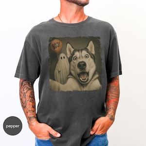 Startled Husky taking a Halloween selfie with a sheet ghost holding an orange BOO balloon in a distressed vintage photo design.