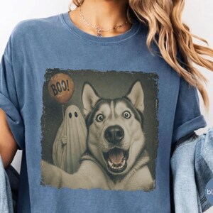 Startled Husky taking a Halloween selfie with a sheet ghost holding an orange BOO balloon in a distressed vintage photo design.