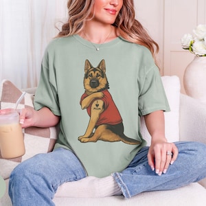 German Shepherd dog illustration wearing a red shirt, lifting sleeve to reveal “I love mom” tattoo, vintage style retro pet graphic, bold clean lines, centered composition, perfect for dog lovers and animal themed apparel designs