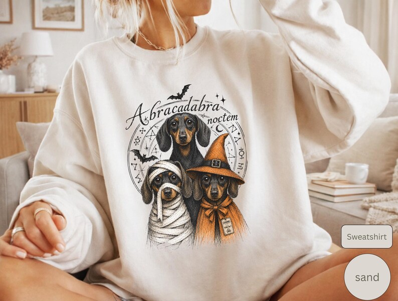 Dachshund Halloween long sleeve and sweatshirt design with three black and tan dogs, mummy wraps, orange witch hat, bats and spell symbols.