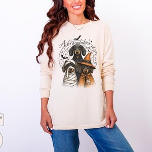 Dachshund Halloween long sleeve and sweatshirt design with three black and tan dogs, mummy wraps, orange witch hat, bats and spell symbols.