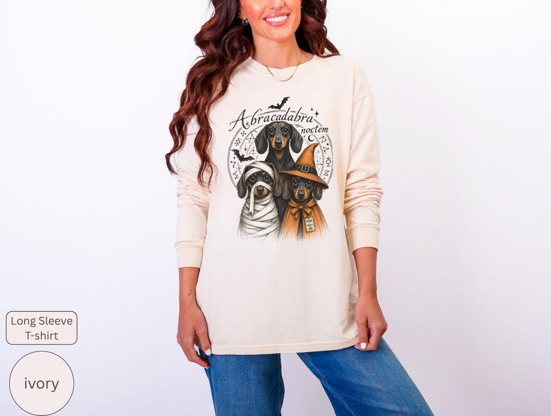 Dachshund Halloween long sleeve and sweatshirt design with three black and tan dogs, mummy wraps, orange witch hat, bats and spell symbols.