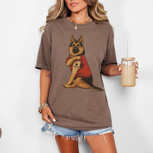German Shepherd dog illustration wearing a red shirt, lifting sleeve to reveal “I love mom” tattoo, vintage style retro pet graphic, bold clean lines, centered composition, perfect for dog lovers and animal themed apparel designs