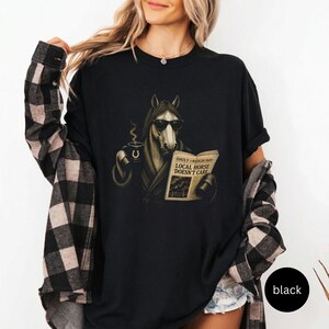 Vintage engraved horse wearing sunglasses and a robe while reading a newspaper and holding a steaming coffee mug. Humorous horse lover design featuring the headline “Local Horse Doesn't Care” in an antique newspaper style. Detailed equestrian artwork with a relaxed, unbothered attitude.