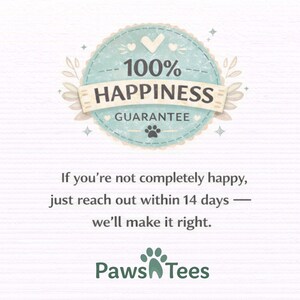 May include: A circular light blue badge with a scalloped edge featuring the text 100% HAPPINESS GUARANTEE and a small paw print. Below, the text reads: If you're not completely happy, just reach out within 14 days &mdash; we'll make it right. Paws Tees.