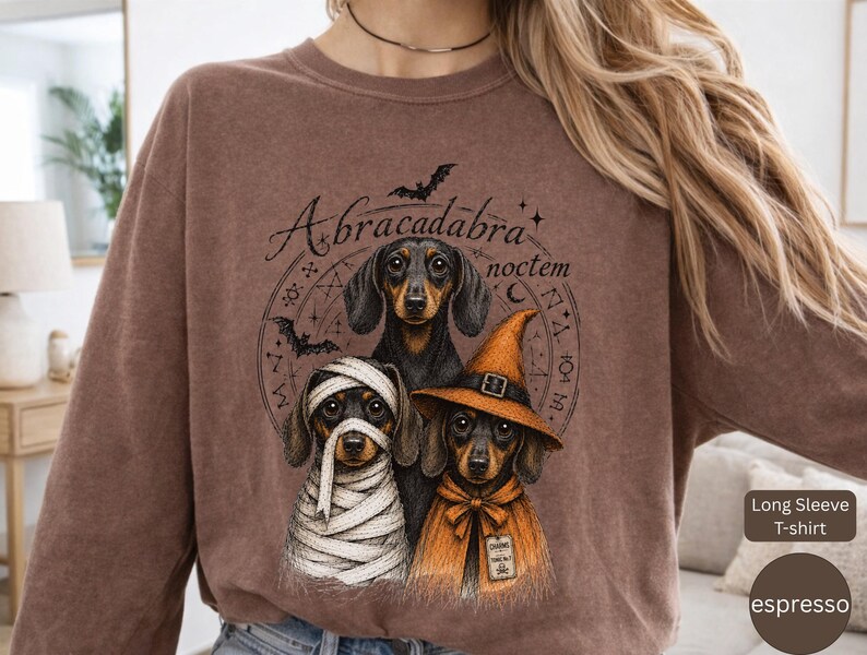 Dachshund Halloween long sleeve and sweatshirt design with three black and tan dogs, mummy wraps, orange witch hat, bats and spell symbols.