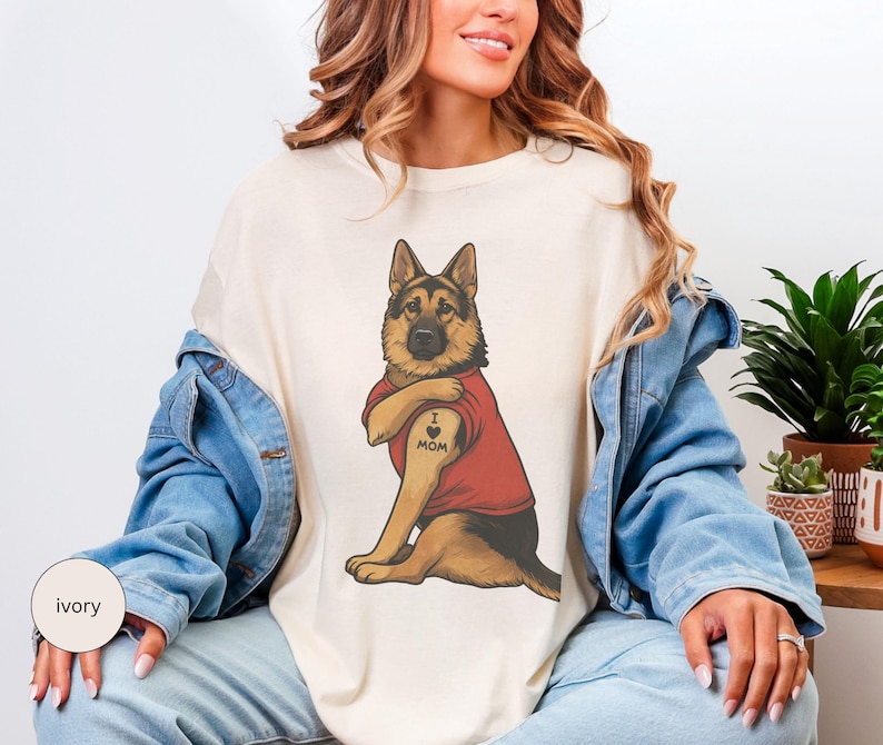 German Shepherd dog illustration wearing a red shirt, lifting sleeve to reveal “I love mom” tattoo, vintage style retro pet graphic, bold clean lines, centered composition, perfect for dog lovers and animal themed apparel designs