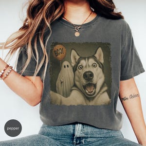Startled Husky taking a Halloween selfie with a sheet ghost holding an orange BOO balloon in a distressed vintage photo design.