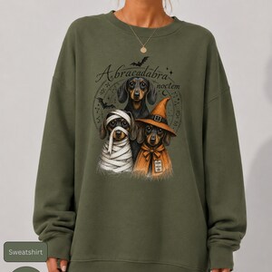 Dachshund Halloween long sleeve and sweatshirt design with three black and tan dogs, mummy wraps, orange witch hat, bats and spell symbols.