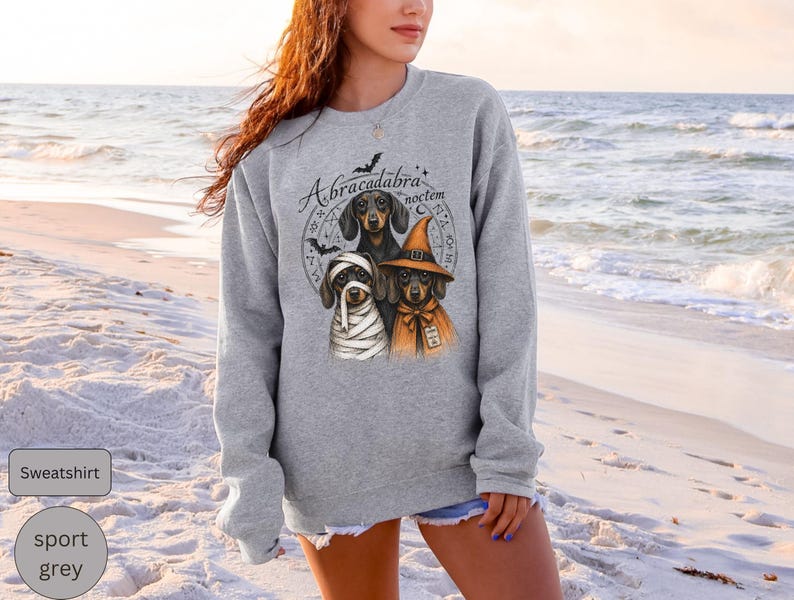 Dachshund Halloween long sleeve and sweatshirt design with three black and tan dogs, mummy wraps, orange witch hat, bats and spell symbols.