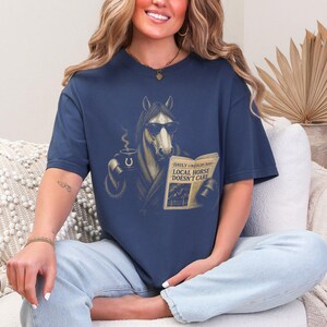 Vintage engraved horse wearing sunglasses and a robe while reading a newspaper and holding a steaming coffee mug. Humorous horse lover design featuring the headline “Local Horse Doesn't Care” in an antique newspaper style. Detailed equestrian artwork with a relaxed, unbothered attitude.