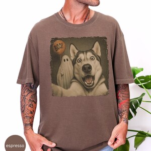 Startled Husky taking a Halloween selfie with a sheet ghost holding an orange BOO balloon in a distressed vintage photo design.