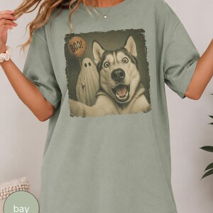 Startled Husky taking a Halloween selfie with a sheet ghost holding an orange BOO balloon in a distressed vintage photo design.
