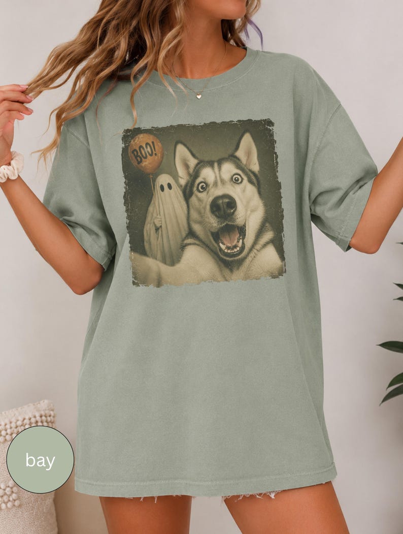 Startled Husky taking a Halloween selfie with a sheet ghost holding an orange BOO balloon in a distressed vintage photo design.