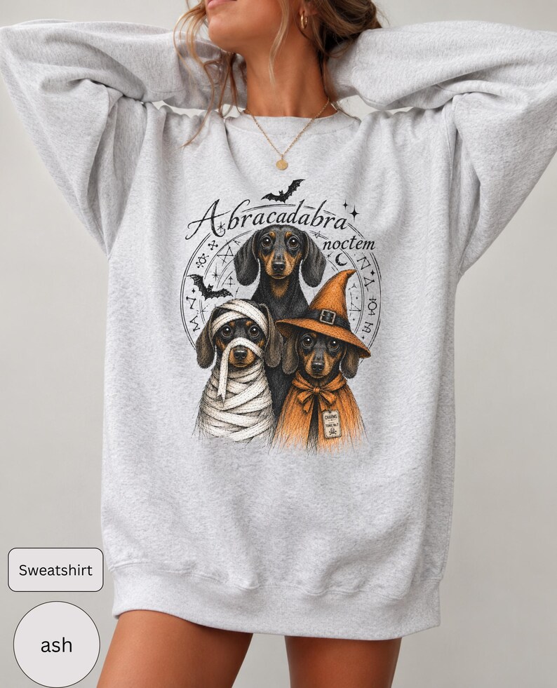 Dachshund Halloween long sleeve and sweatshirt design with three black and tan dogs, mummy wraps, orange witch hat, bats and spell symbols.
