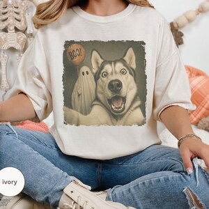 Startled Husky taking a Halloween selfie with a sheet ghost holding an orange BOO balloon in a distressed vintage photo design.