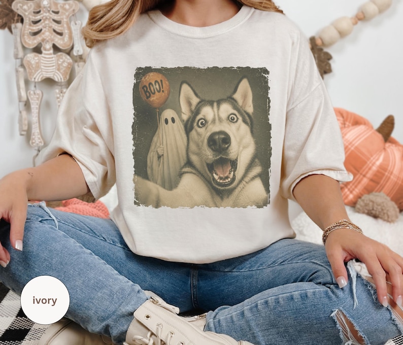Startled Husky taking a Halloween selfie with a sheet ghost holding an orange BOO balloon in a distressed vintage photo design.