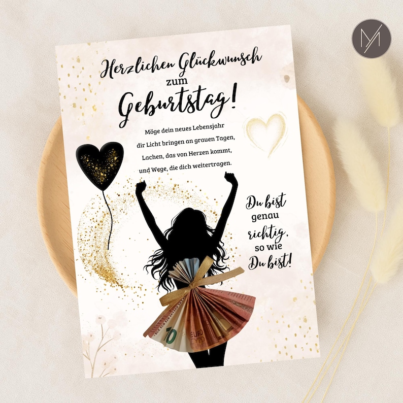 May include: A birthday greeting card with German text and a silhouette of a person with arms raised. The person's skirt is made of folded Euro banknotes. A black heart balloon and gold accents decorate the card.