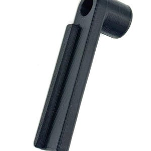 May include: A black, 3D-printed tool with a cylindrical handle and a right-angled head featuring a circular opening. The handle has a ridged design, and the tool appears to be made of plastic. The object is set against a white background.